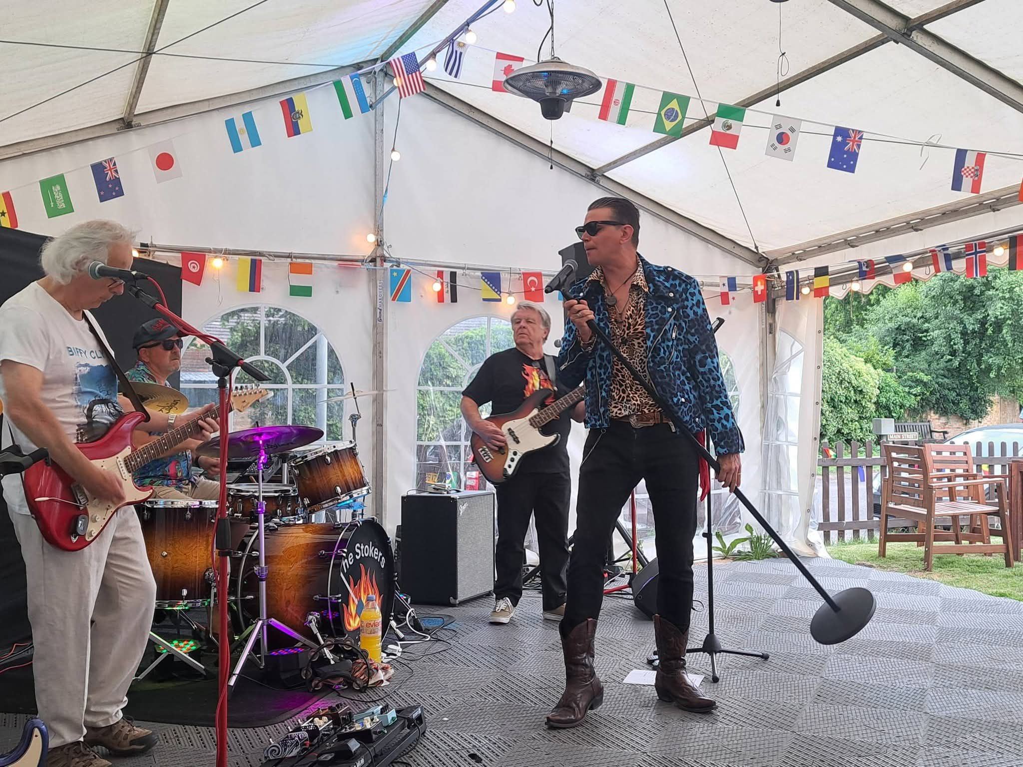 A live band playing and singing on stage at The Chandos Arms, performing to a full room.