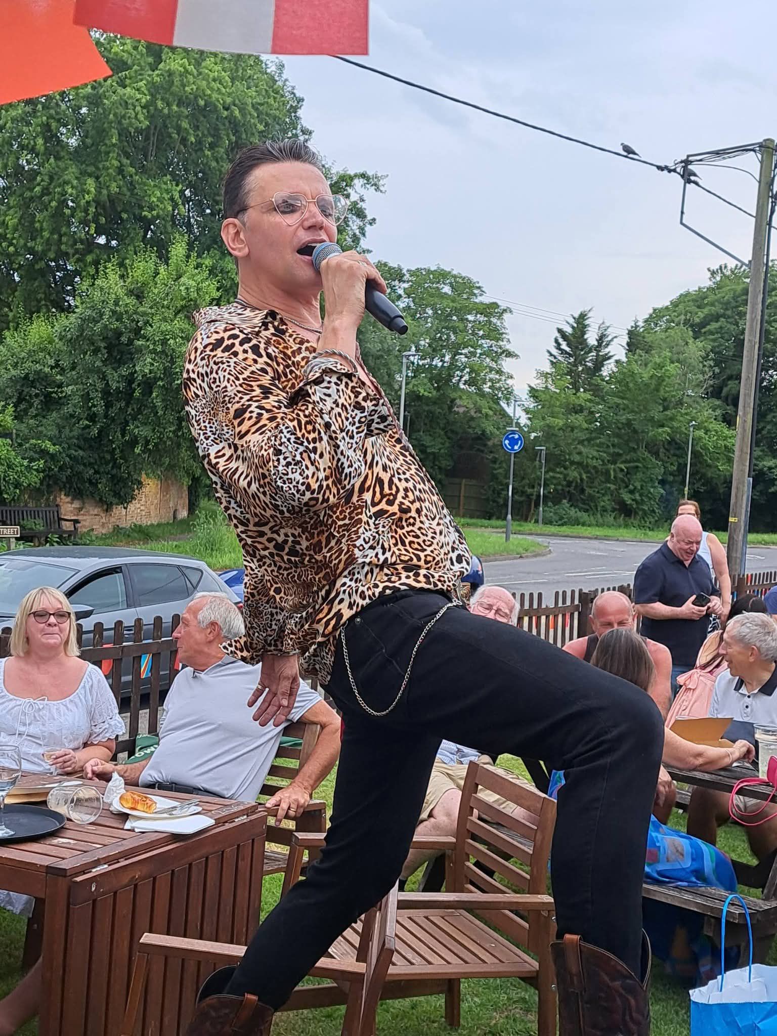 A singer captured close up, mid-song with microphone in hand during a live music night at The Chandos Arms.