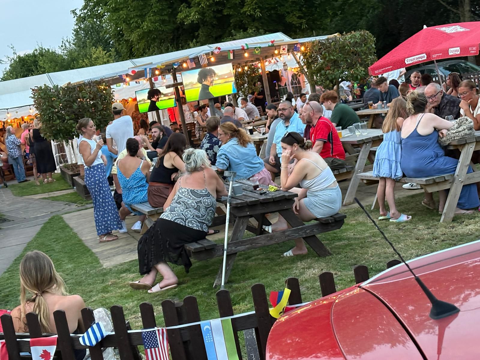 People relaxing and chatting together in the garden at The Chandos Arms on a sunny day.