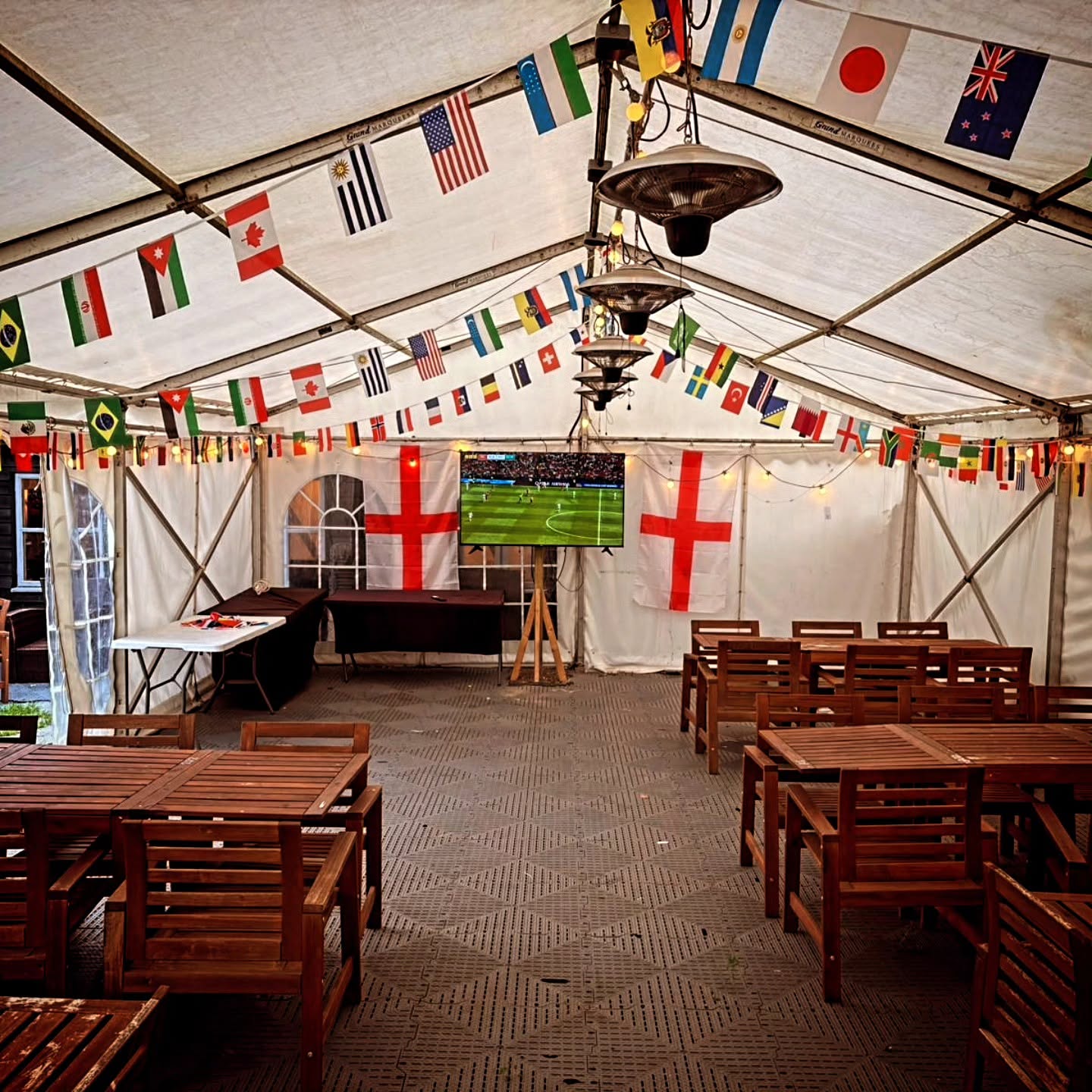 Bunting and flags strung above tables inside the marquee